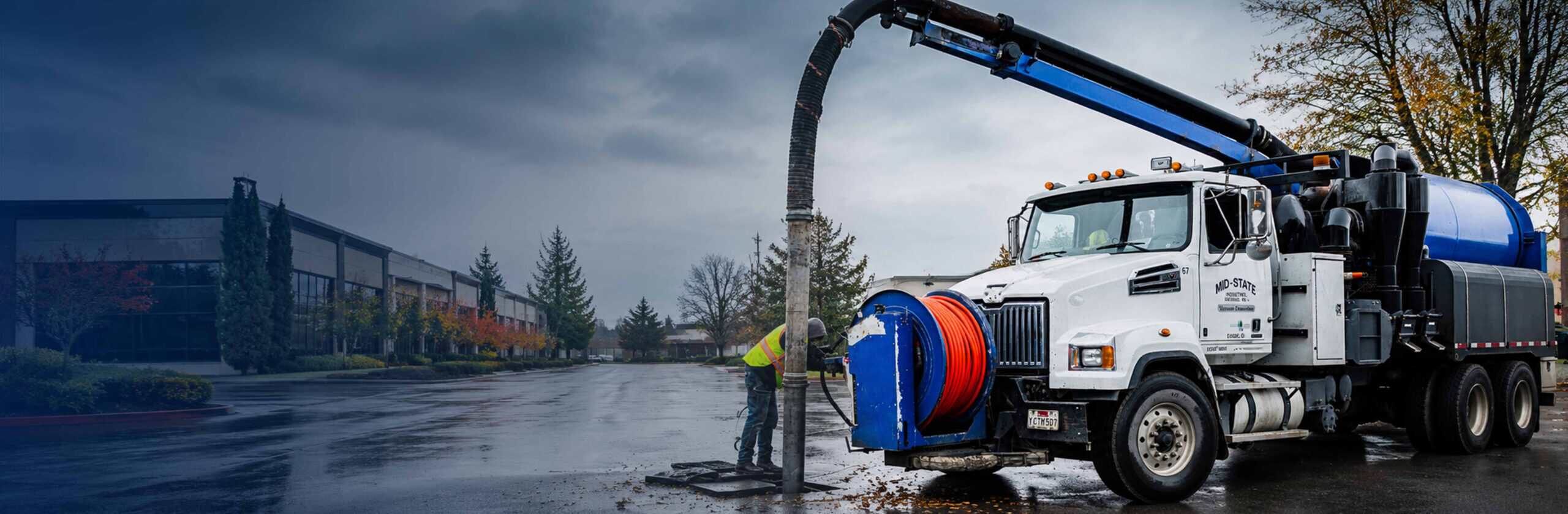 Mid-State vacuum truck and crew working at a parking-lot storm drain.
