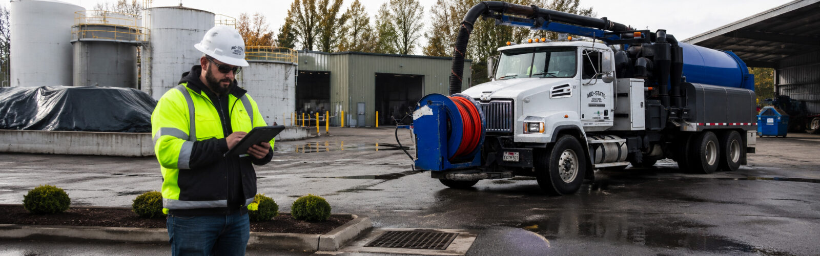 Mid-State Industrial vacuum truck and technician conducting a stormwater compliance inspection at an Oregon industrial facility.