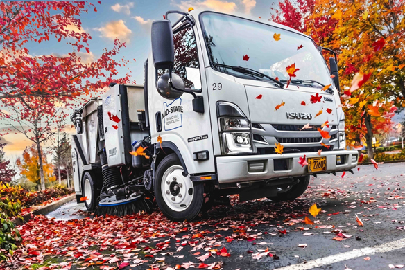 Mid-State Industrial street sweeper removing fall leaves from a curbside parking lot in Oregon.