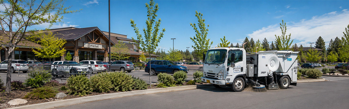 Mid-State Tymco sweeper cleaning a grocery store parking lot in Oregon.