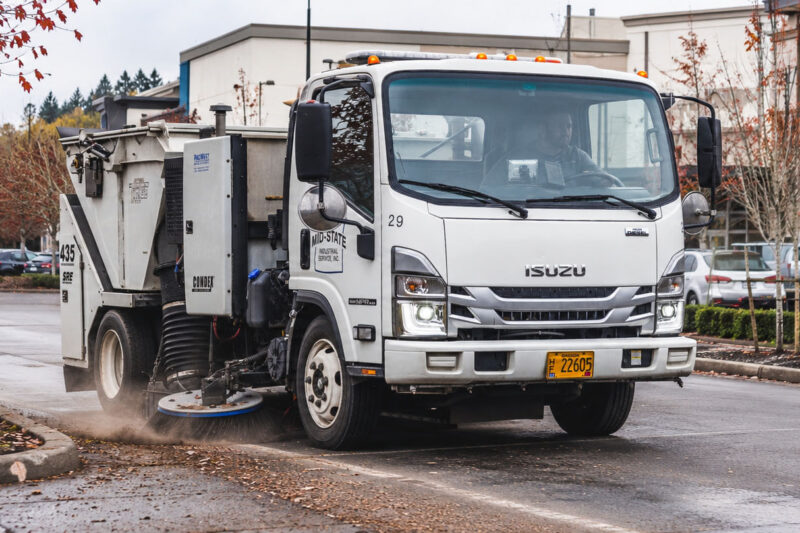 Mid-State Tymco sweeper cleaning debris from an Oregon shopping center parking lot.