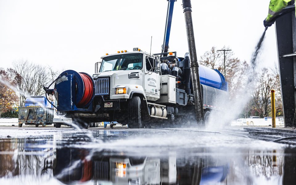 Mid-State drain jetting truck with hose reel and water spray on an Oregon job site